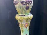 un vase posé par terre à côté d'un cadre photo
