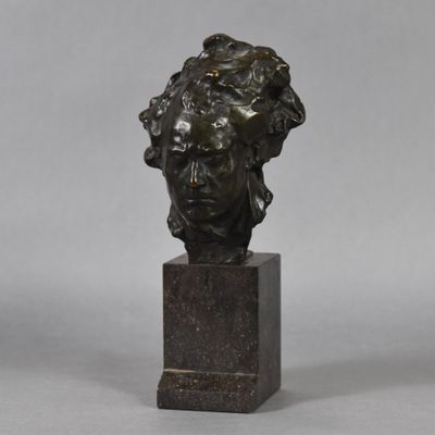 a bronze bust of a woman on a marble base