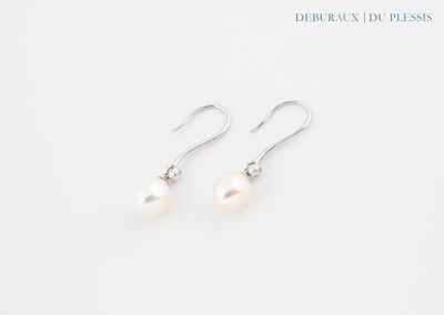 une paire de boucles d'oreilles en perles blanches sur fond blanc