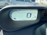 a car dashboard with a speedometer and a car in the background