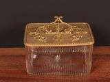 an antique glass box on a wooden table with a black background
