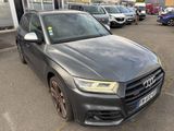 the audi q3 is parked in a parking lot with other cars in the background