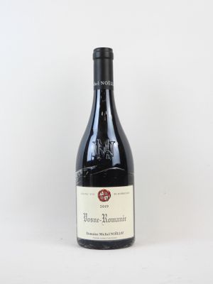 une bouteille de vin rouge posée sur une table blanche
