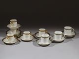 Plusieurs tasses et soucoupes sont alignées sur une table
