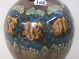 a brown vase with blue and yellow designs on it