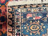 an image of a blue and pink rug with a cat laying on top of it