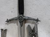 une épée et un couteau sur une table à côté d'autres objets