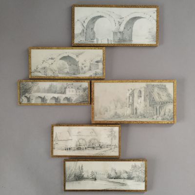 several framed drawings hang on the wall of a room