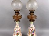 paire de lampes anciennes en porcelaine, montées sur des socles en bois et dotées de globes en verre