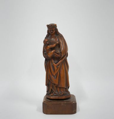 une vieille statue en bois représentant une femme tenant un enfant dans ses bras