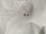 a close up of a white shirt with a red stitching on it