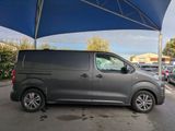 a grey van parked under a blue umbrella in a parking lot