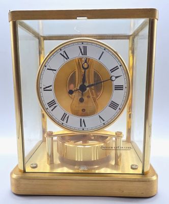 une horloge en or avec des chiffres romains, exposée dans une vitrine