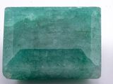 a close up of a green emerald stone on a white surface