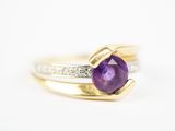 un gros plan d'une bague ornée d'une pierre violette