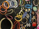a lot of bracelets and necklaces on a black surface
