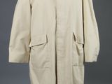 une blouse blanche posée sur un mannequin, sur fond gris