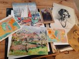 many paintings on the table with a woman in the background