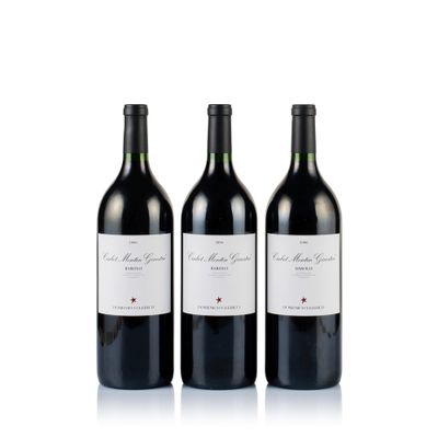 three bottles of red wine sitting next to each other on a white surface