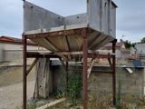 a concrete structure sitting on top of a dirt field