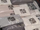 many bags of t - shirts on display in a store
