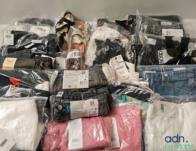 une grosse pile de vêtements posée sur une étagère