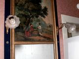 un tableau accroché au mur au-dessus d'un miroir dans une salle de bains