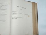an open book on a table with a glass of wine
