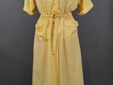 une robe jaune sur un mannequin, sur fond gris