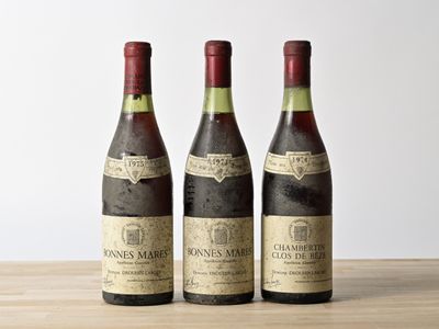 three bottles of wine sitting on top of a wooden table