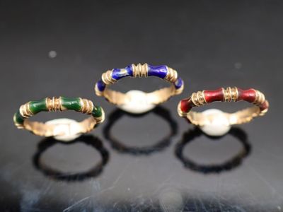 trois anneaux de couleurs différentes sur une surface noire, avec un fond noir