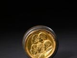 une image représentant une pièce d'or posée sur une surface noire