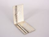 a silver box with a cigarette in it on a white surface