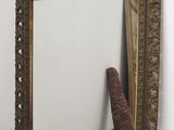 un miroir posé sur une étagère à côté d'un vase