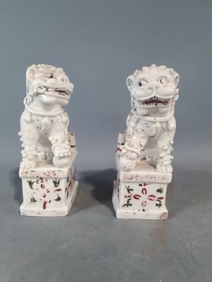 une paire de statuettes « foo foo » blanches ornées de motifs rouges et noirs