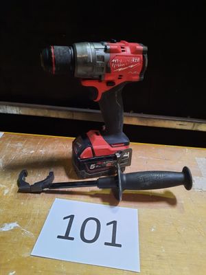 une perceuse posée sur une table sur laquelle est inscrit un chiffre