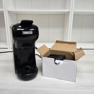 a black coffee maker and a box on a table