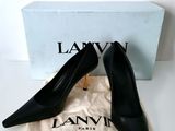 a pair of black shoes sitting on top of a white bag