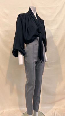 a mannequin wearing a black top and grey pants