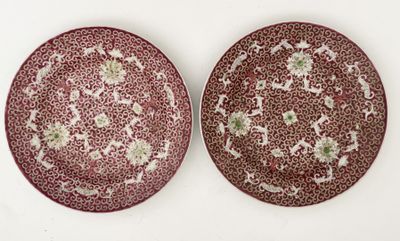 two red and white plates with floral designs on them on a white surface