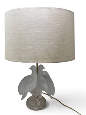 a white lamp with two birds on it on a table