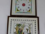 trois tableaux encadrés accrochés au mur au-dessus d'une horloge