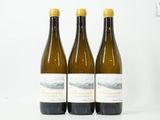 trois bouteilles de vin posées sur une table blanche