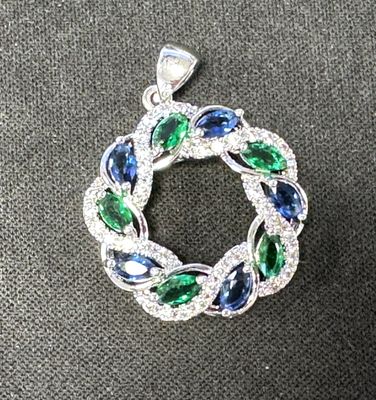 un gros plan d'un pendentif bleu et vert sur une surface noire