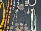 many different necklaces and bracelets laid out on a table