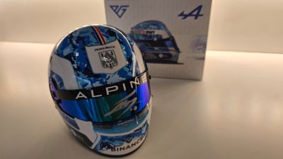 casque d'un pilote de course posé à côté d'une boîte sur une table