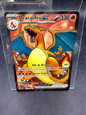 une carte Pokémon dans une boîte transparente posée sur une table