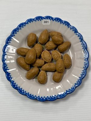 une assiette d'amandes posée sur une table blanche