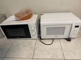 two microwaves that are sitting on the floor next to each other