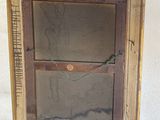 an old picture frame sitting on top of a table next to a window